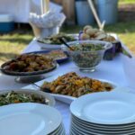 Island Girl Catering buffet table with warm-spiced chicken and local greens salad